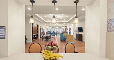 A bright common area with dining setup and fruit basket