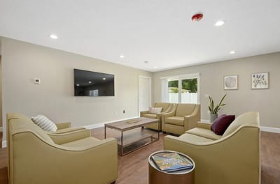 Bright common area with seating and a TV
