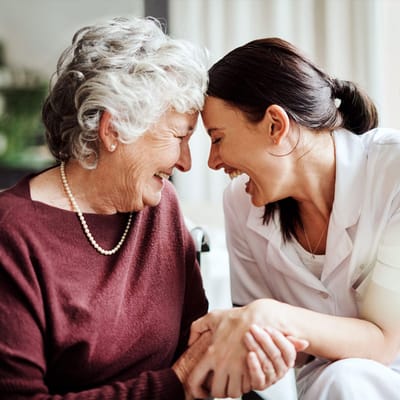 A caregiver sharing a joyful moment with a resident
