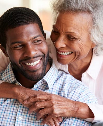 A senior woman and a man smiling together, showcasing connection and care.