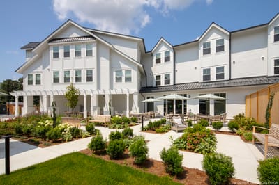 Exterior view of a senior living facility with outdoor seating