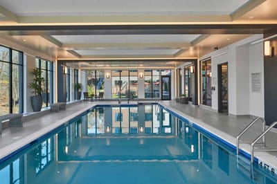 Indoor swimming pool with natural light and seating areas