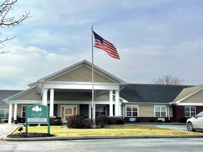 Exterior view of The Oaks Health Center with flag