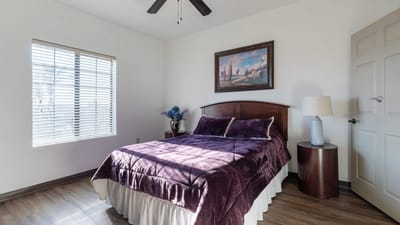 Brightly lit private bedroom with a bed and decor