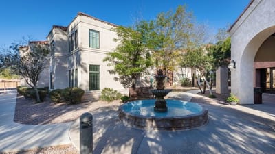 Outdoor space featuring a fountain and landscaped area