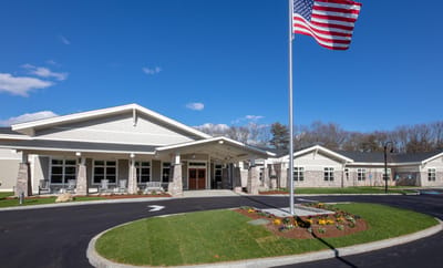 Exterior view of a senior living facility with flag