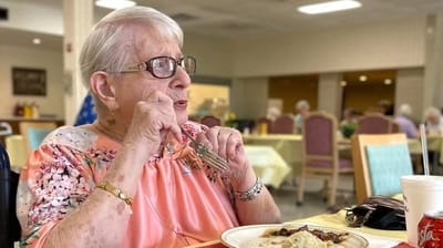 Resident enjoying a meal in a dining area