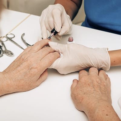 A caregiver giving a manicure to a resident