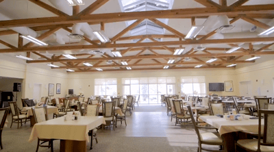 Dining area with tables and chairs under a bright ceiling