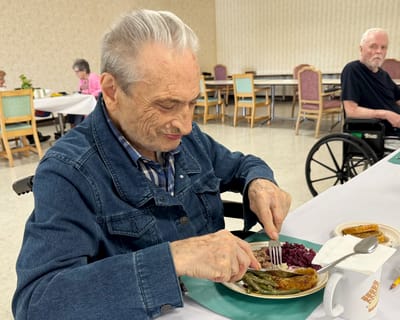 Resident enjoying a meal in the dining room