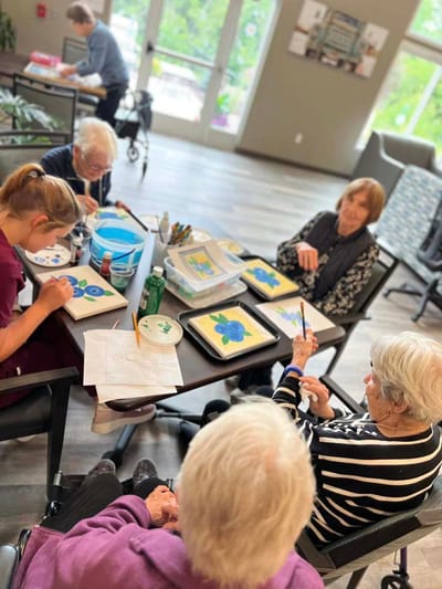 Residents engaging in an art activity at a table