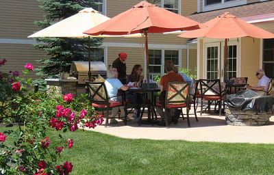 Residents enjoying time outdoors under umbrellas