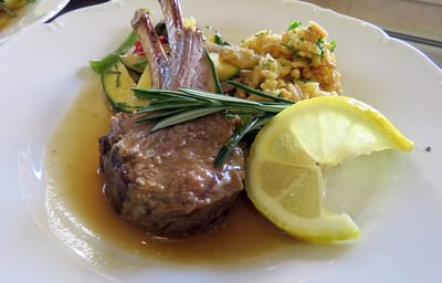 Gourmet meal with lamb, vegetables, and lemon