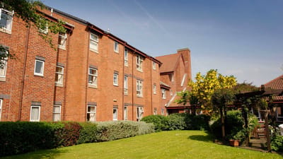 Exterior view of a senior living facility with gardens