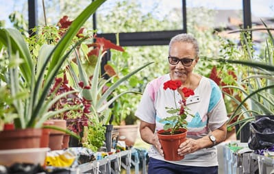 Resident gardening in a vibrant indoor greenhouse