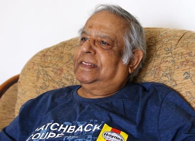 An elderly man sitting comfortably on a couch