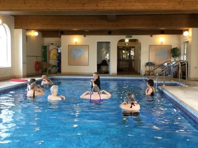 Residents participating in a water aerobics class in a pool