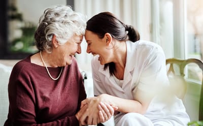 A caregiver and resident sharing a joyful moment