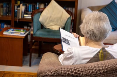 A resident reading a book in a cozy living area