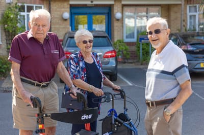 Three residents chatting outside the facility