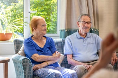 Two residents conversing in a bright room