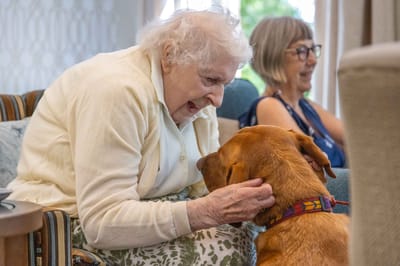 Resident joyfully interacting with a dog