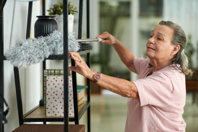 A resident cleaning a shelf in an interior space