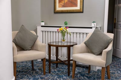 Cozy common area with two chairs and flowers