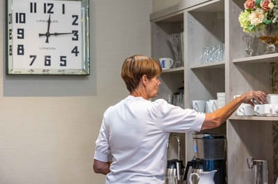 Staff member arranging cups in the dining area