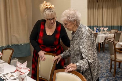Staff assisting a resident in a dining area