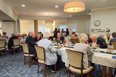 Residents enjoying dinner in a dining room