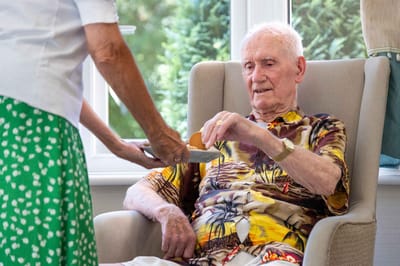 Staff member assisting a resident in a cozy seating area