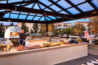 Outdoor dining area with chef preparing meals.