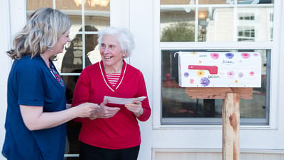 Staff engaging with a resident by a decorated mailbox