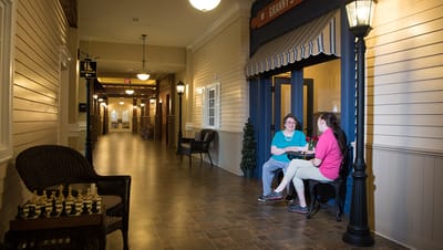Residents chatting in a bright corridor with seating