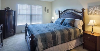 A well-furnished private resident room with a bed and decor