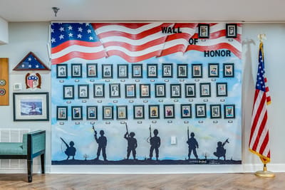 Wall of honor displaying framed photos and American flags