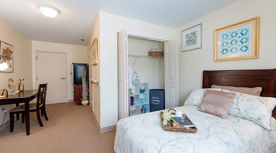 A cozy resident room showing a bed and seating area