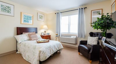 Cozy resident room with a bed and a chair