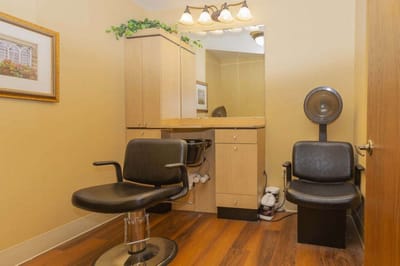 Interior of a hair salon with styling chairs and mirror