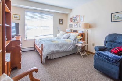 Cozy resident room with a bed and chair