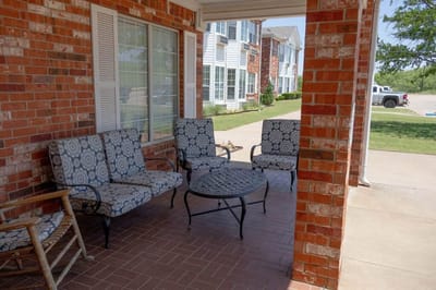 Outdoor seating area with patterned chairs and a table.