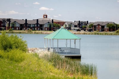 Gazebo by the lake with residential buildings in the background