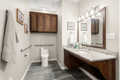 Modern bathroom with vanity and decorative frames.