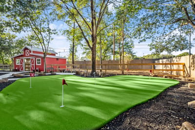 Outdoor putting green with a red shed