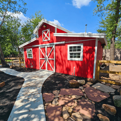 A red barn structure in a landscaped area.
