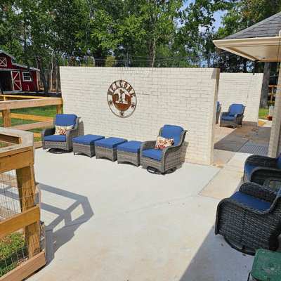 Outdoor seating area with lounge chairs and decorative wall.