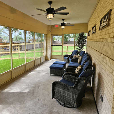 Sunlit screened-in porch with comfortable seating.