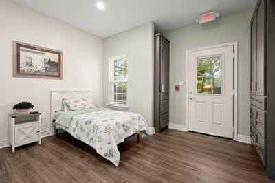 Private resident room with a bed and natural light.
