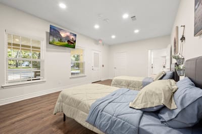 Private resident room with two beds and a TV.